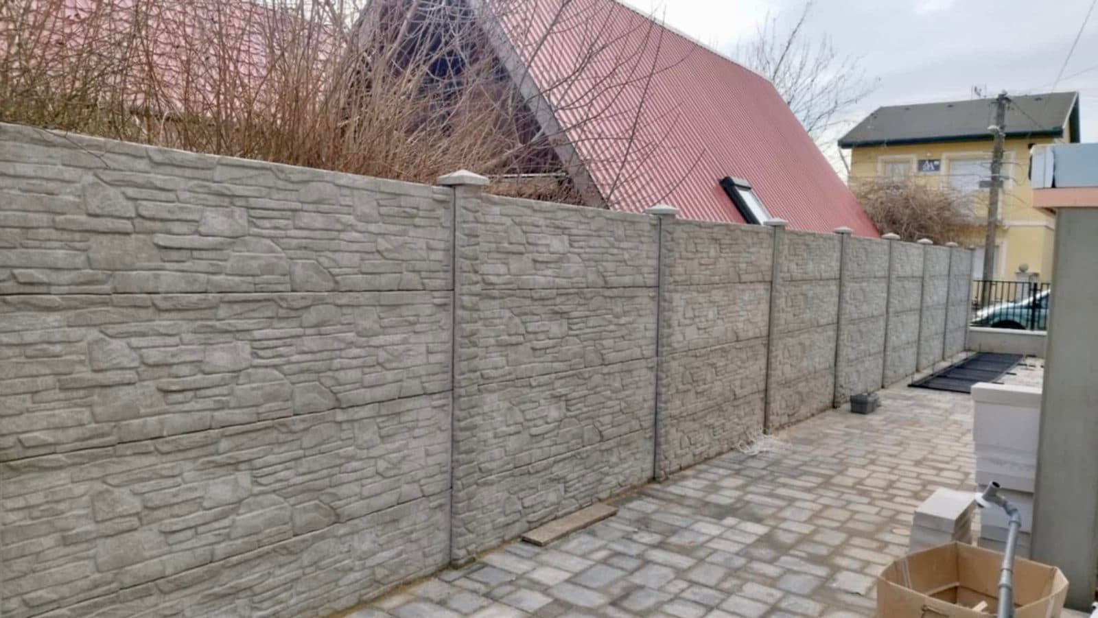 Kőmintás betonkerítés kövezett udvarban